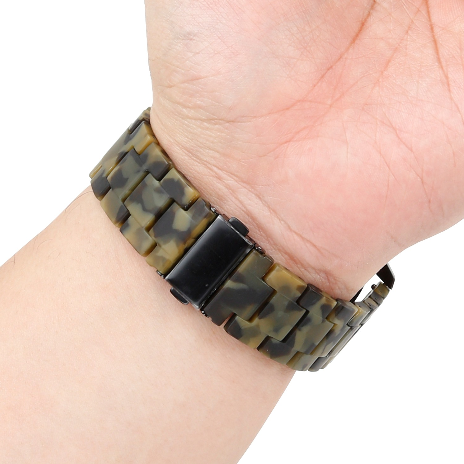 Das Handgelenk einer Person mit einem Camouflage-gemusterten Uhrenarmband.