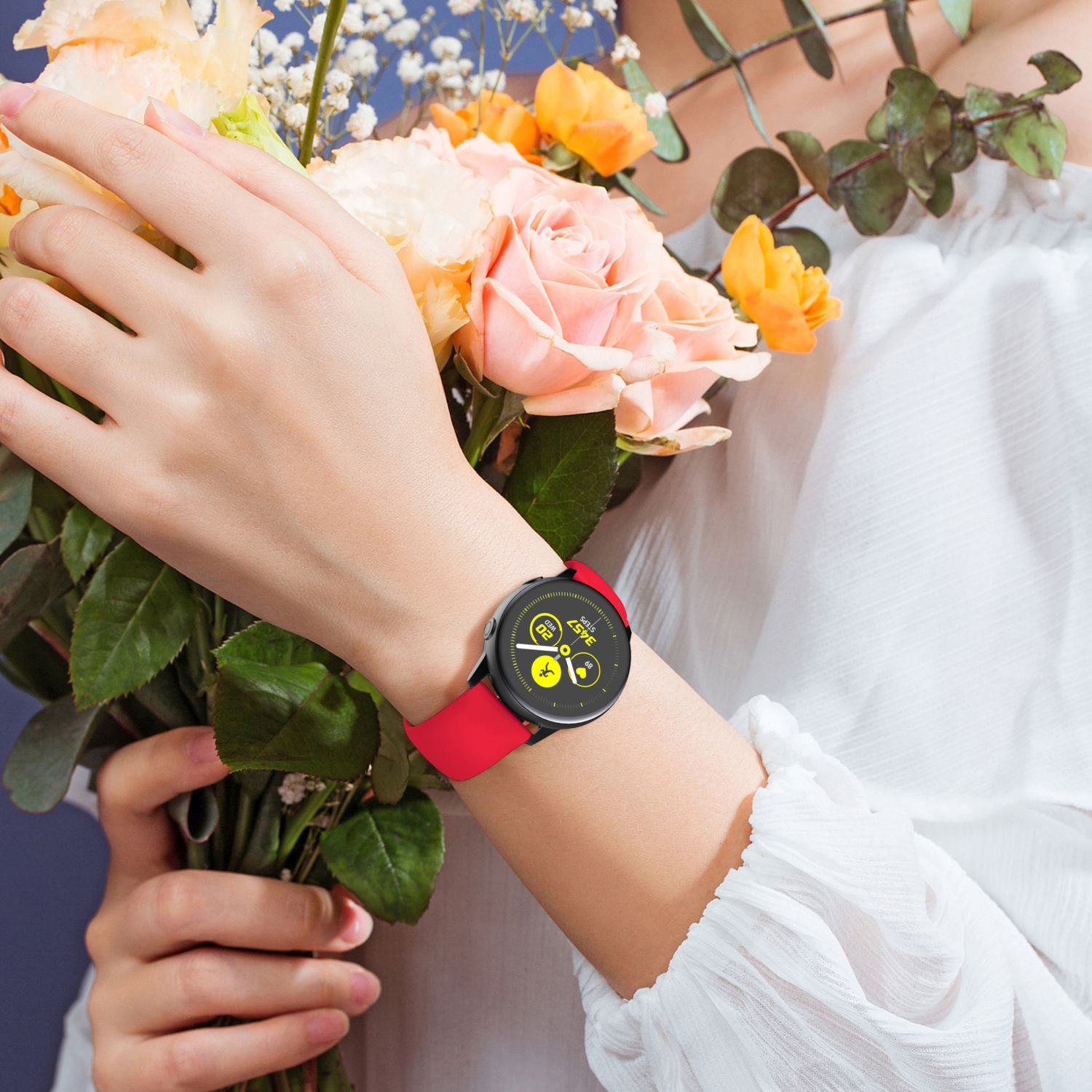 Handgelenk einer Person mit roter Smartwatch und einem Blumenstrauß.