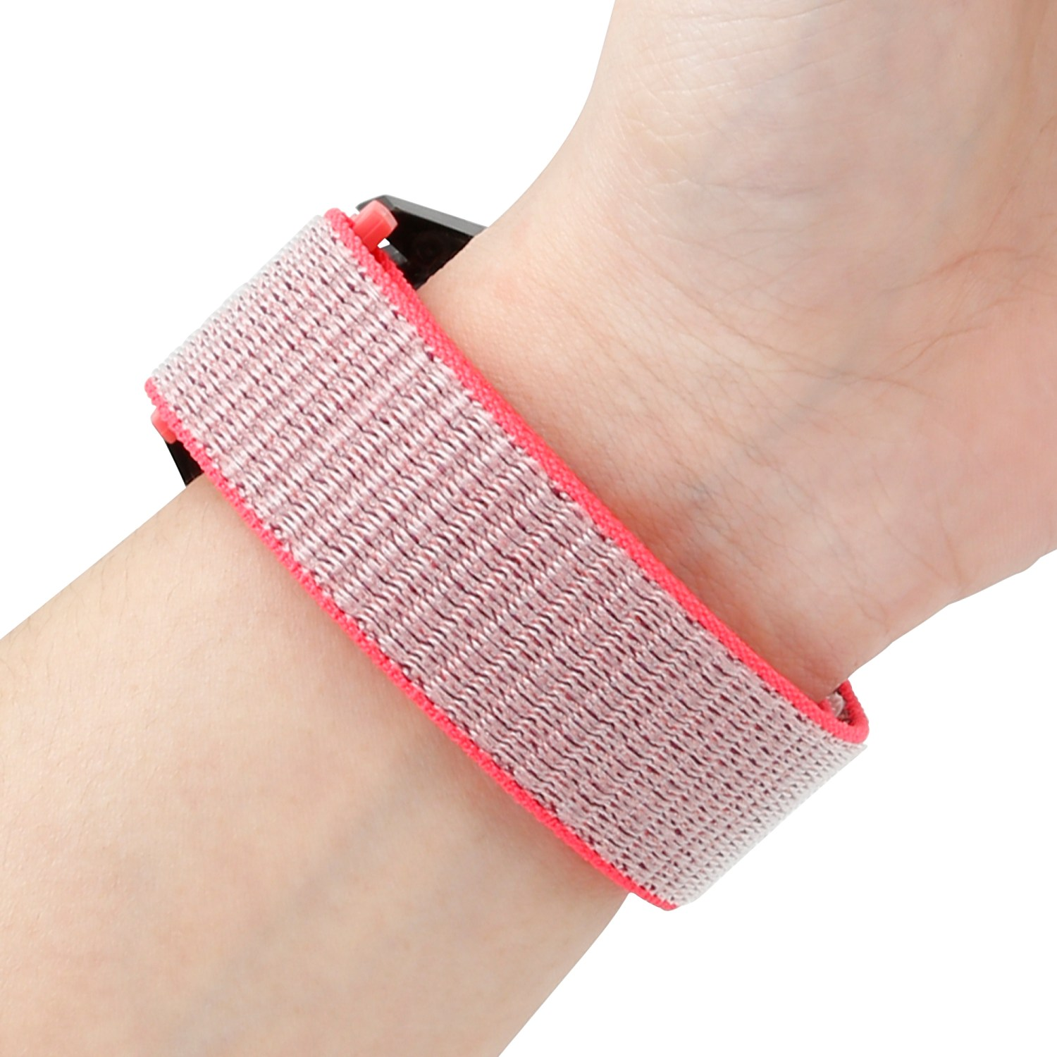 Ein Handgelenk mit einem rosa-weiß gestreiften Stoff-Armband. Das Band ist mit einem schwarzen Zifferblatt verbunden.