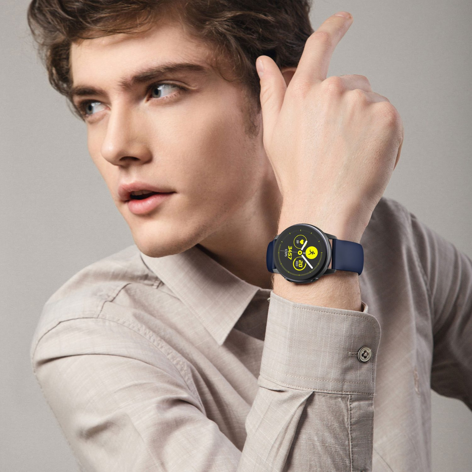Ein Mann trägt eine Smartwatch am Handgelenk. Die Uhr hat ein blaues Armband und ein rundes Display.