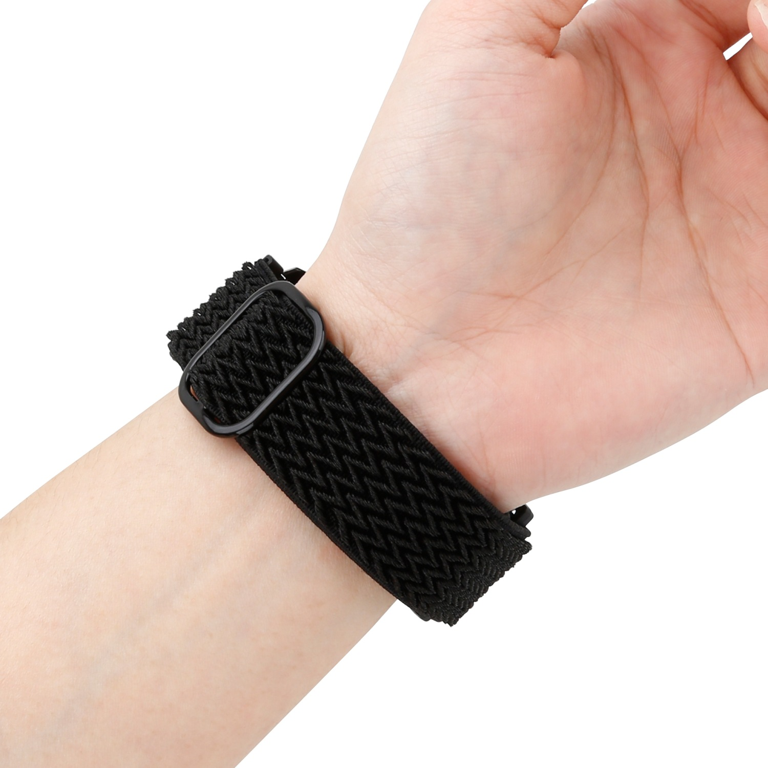 Die Hand einer Person mit einem schwarzen, gewebten, elastischen Uhrenarmband mit schwarzer Schnalle am Handgelenk.