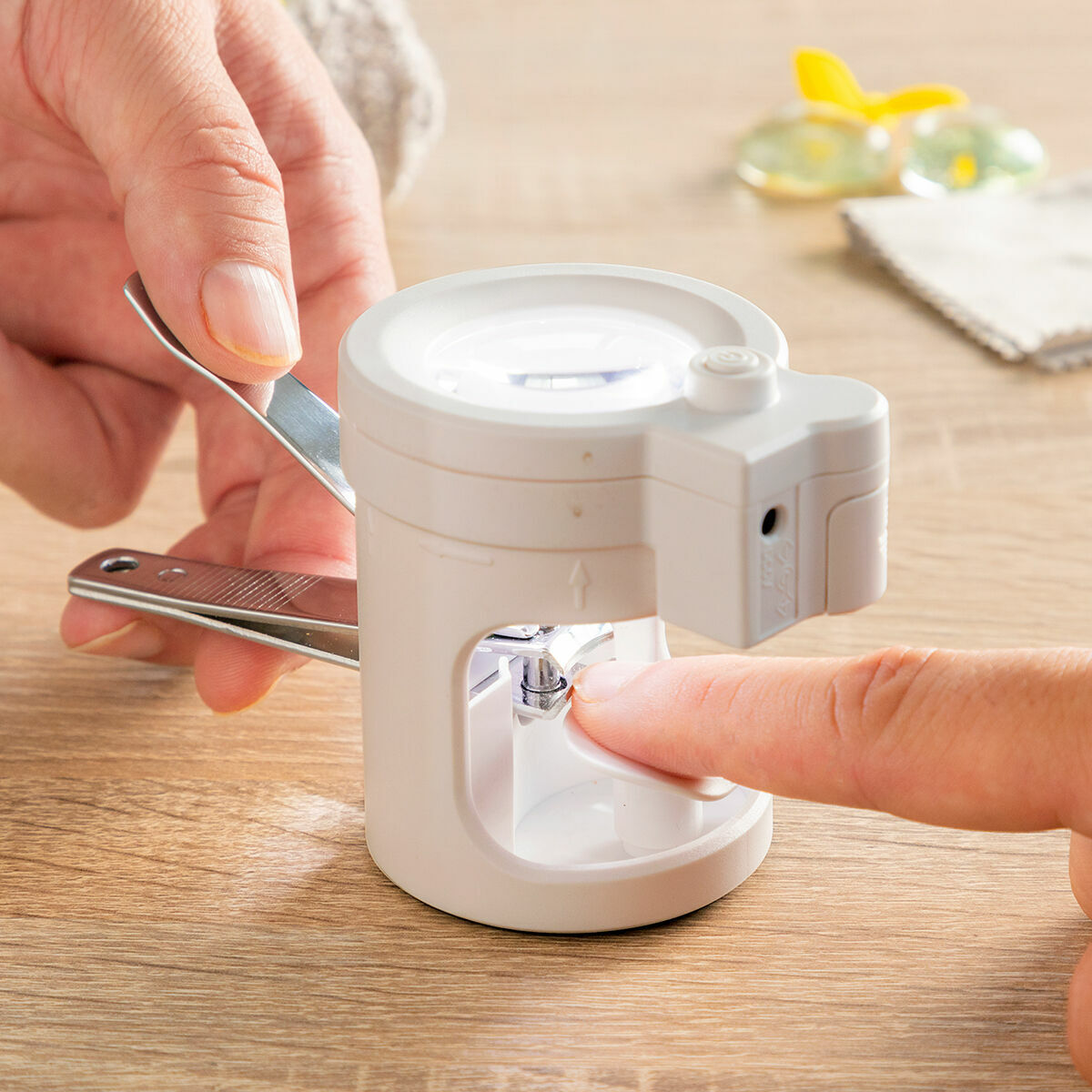 Ein weißer Nagelknipser mit Licht wird an einem Finger verwendet.