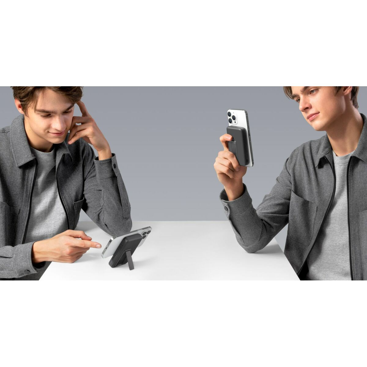 Zwei Männer betrachten Smartphones. Einer hält ein Telefon mit Hülle, der andere zeigt auf ein Telefon auf einem Ständer.