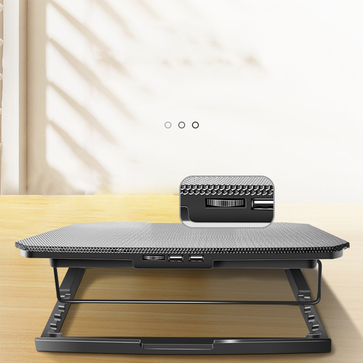 Schwarzer und silberner Laptop-Kühler auf einem Holztisch mit Bedienfeld.