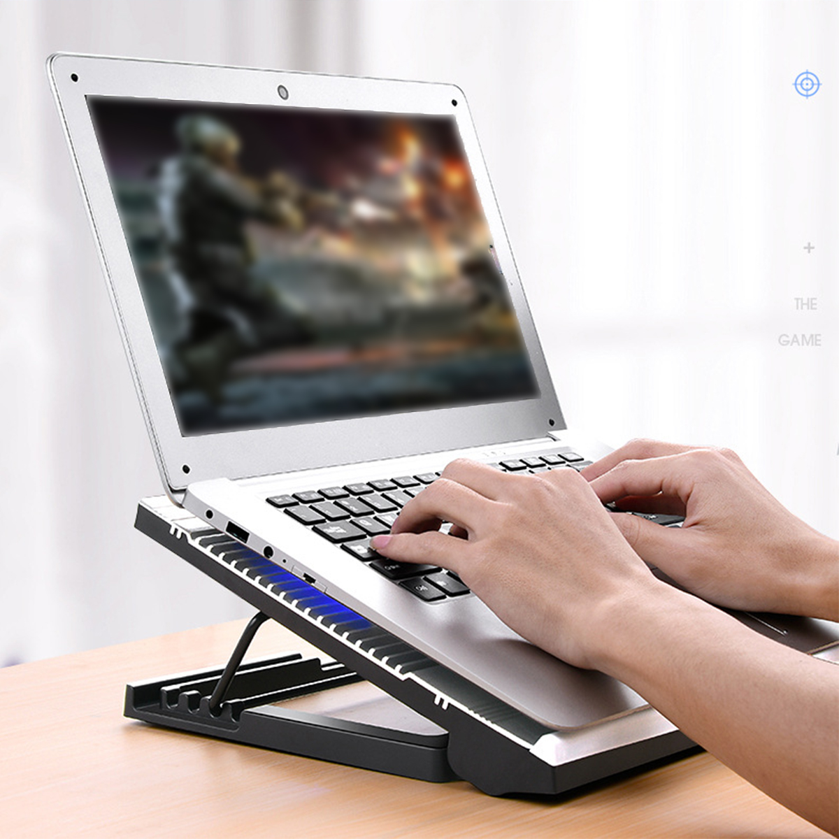 Laptop auf einem Ständer. Person benutzt die Tastatur. Blaues Licht.