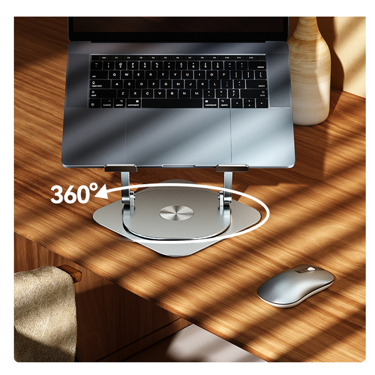 Laptop auf silbernem Ständer, Maus rechts. Holztisch mit Vase.