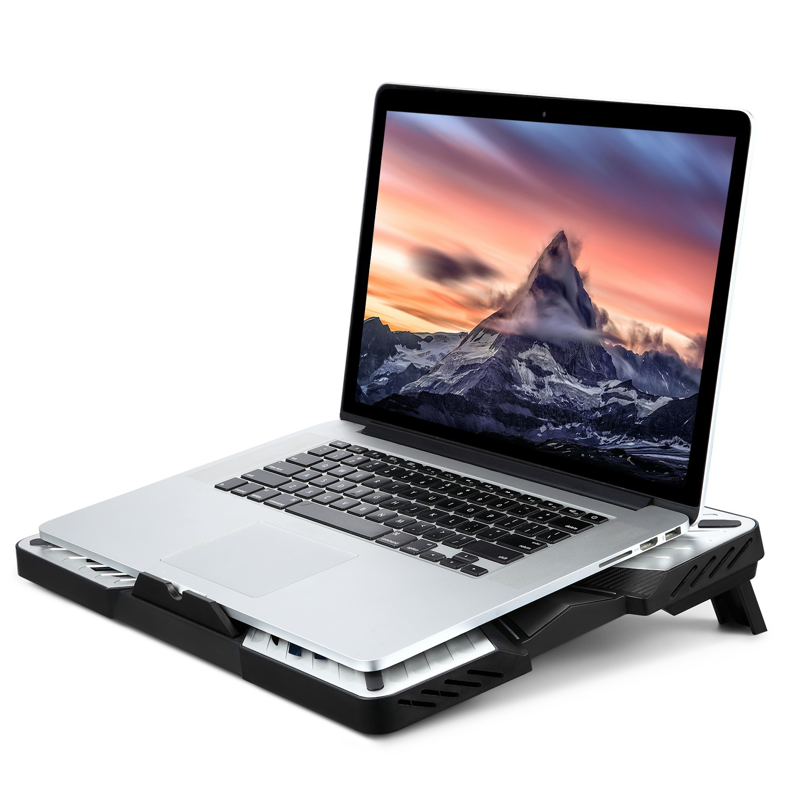 Laptop auf einem Kühlpad. Der Bildschirm zeigt eine Berglandschaft mit Sonnenuntergang.