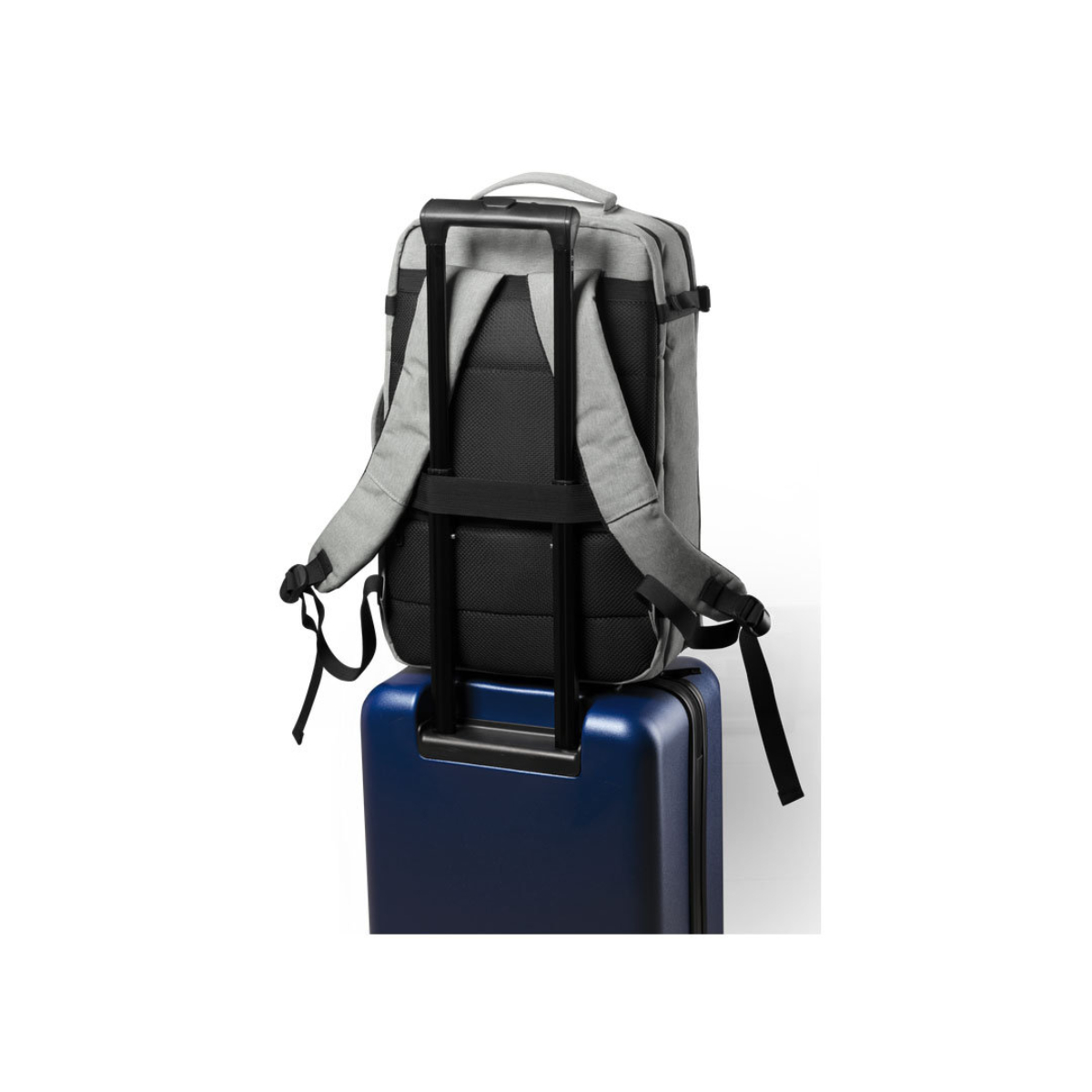 Una mochila gris se apoya sobre una maleta azul. La mochila tiene correas negras y un asa.