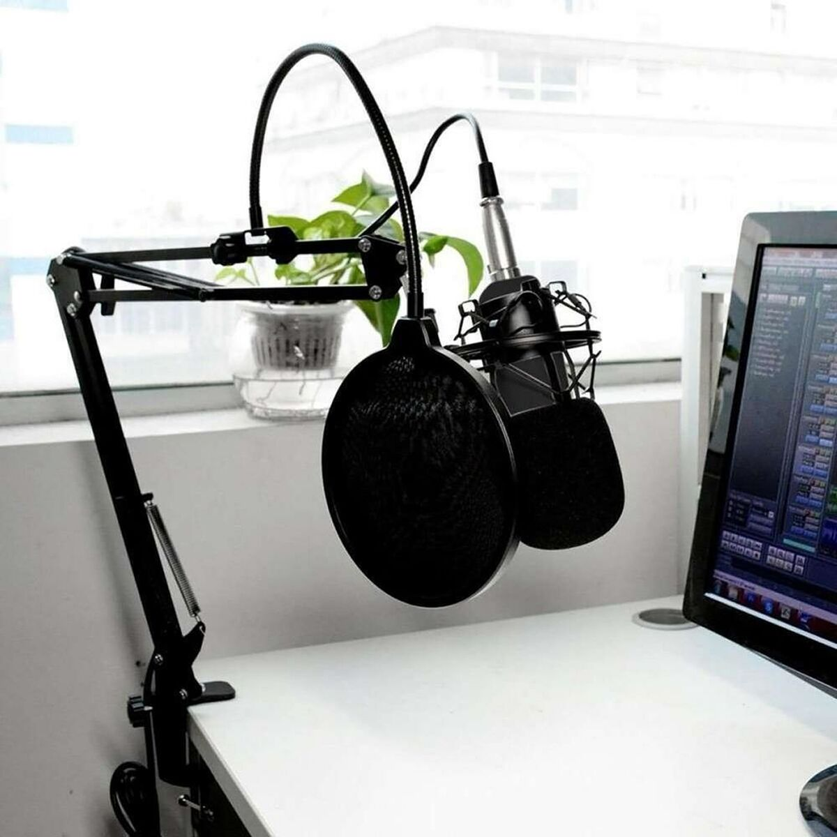 Mikrofon-Setup mit Pop-Filter und Ständer auf einem Schreibtisch.