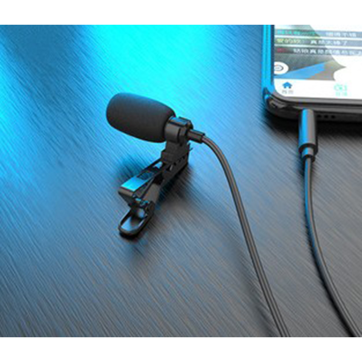 Ein schwarzes Ansteckmikrofon mit Schaumstoffabdeckung, das mit einem Smartphone verbunden ist.