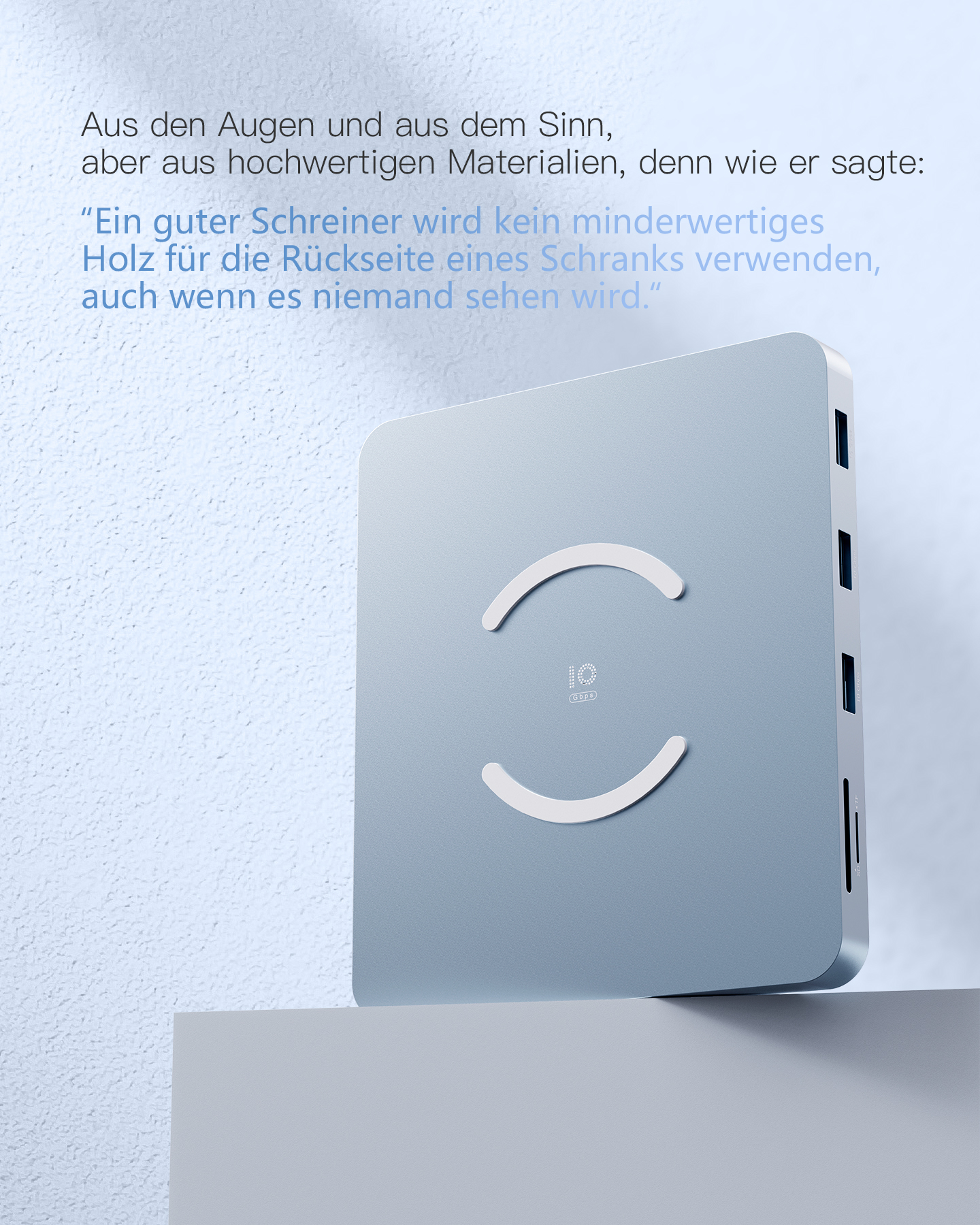 Ein graues Gerät mit Symbolen für kabelloses Laden und Anschlüssen. Es steht auf weißer Oberfläche mit blauem Hintergrund.