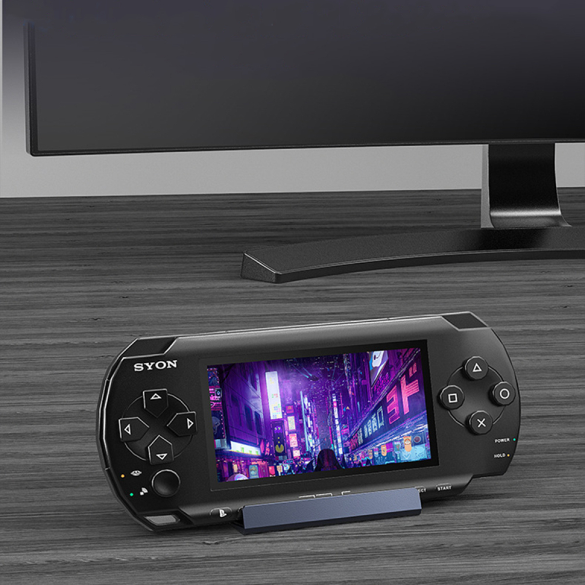 Schwarze tragbare Spielkonsole mit Bildschirm, der ein Videospiel zeigt, auf einer Holzoberfläche.