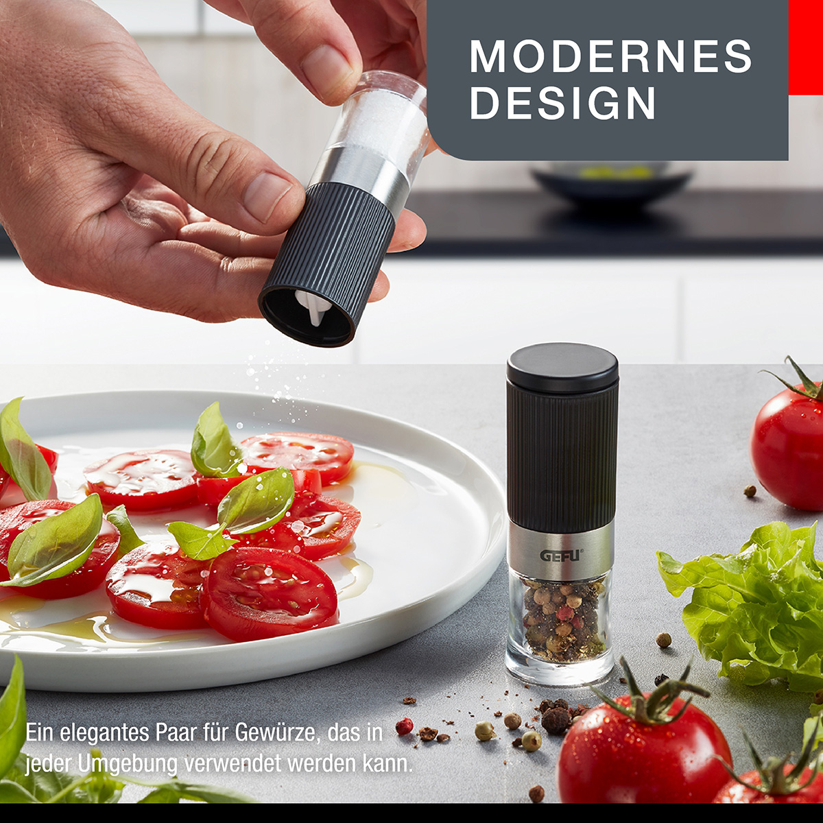 Eine Person mahlt Pfeffer über einen Teller mit Tomaten. Eine Pfeffermühle ist sichtbar.