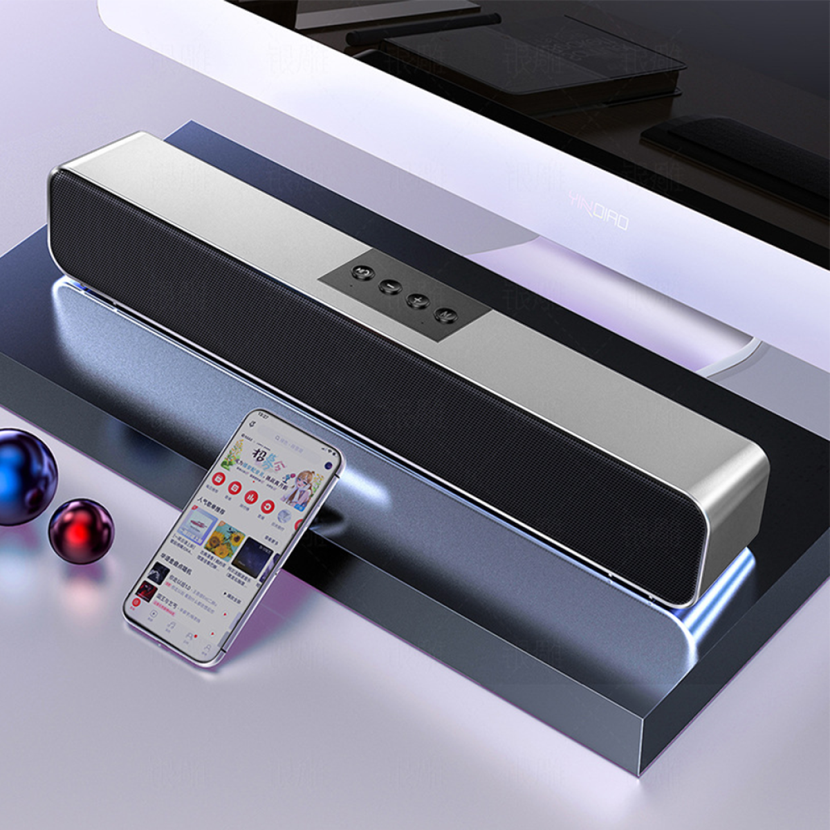 Eine elegante silber-schwarze Soundbar mit Smartphone und farbigen reflektierenden Kugeln.