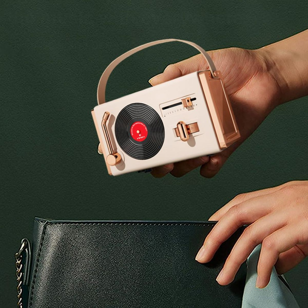 Eine Hand lässt einen kleinen Musikplayer im Retro-Stil in eine Tasche fallen.