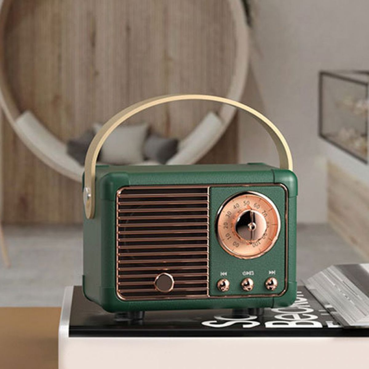 Grünes Retro-Radio mit goldenen Akzenten und Griff, auf einem Buch.