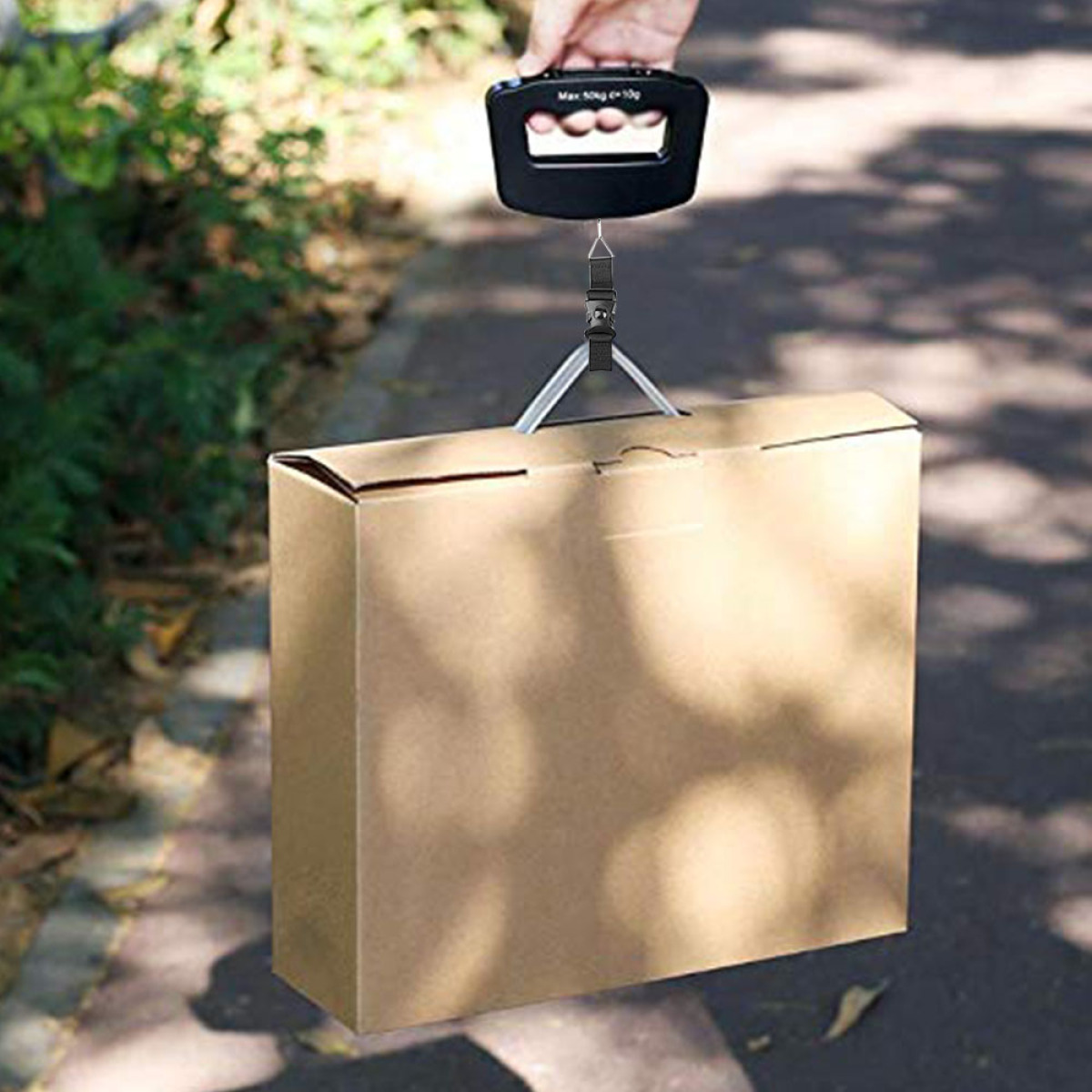 Eine Box wird mit einer kleinen Digitalwaage gewogen.