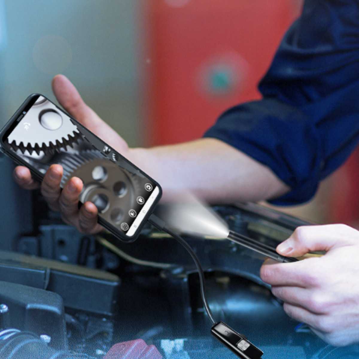 Een persoon gebruikt een smartphone met een inspectiecamera om de binnenkant van een automotor te bekijken.