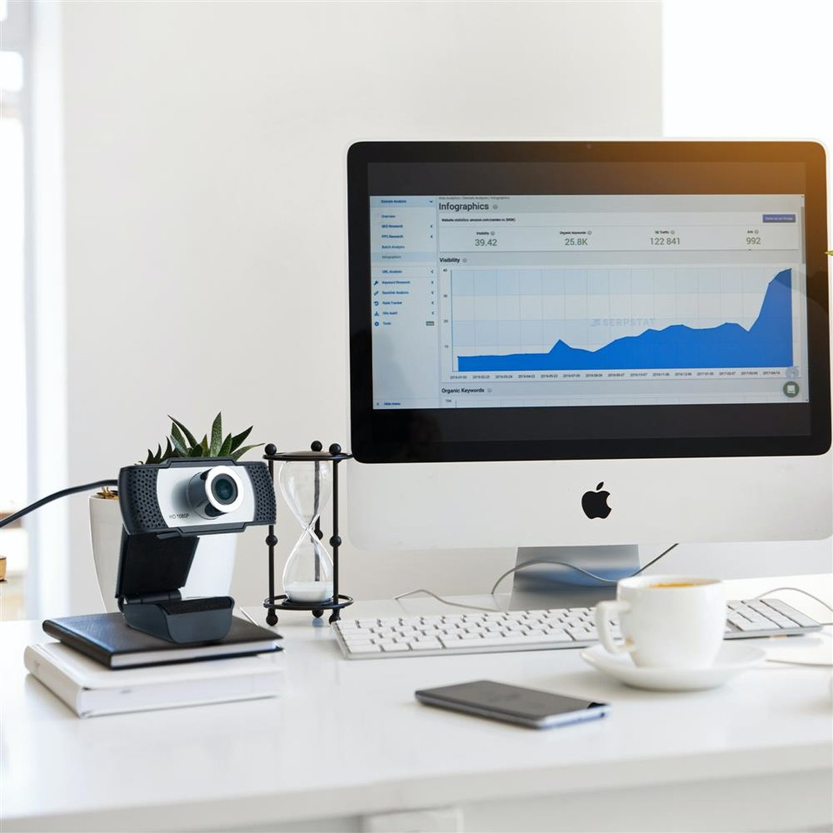 Ein Schreibtisch mit Computer, Webcam und anderem Zubehör. Der Computerbildschirm zeigt ein Diagramm.