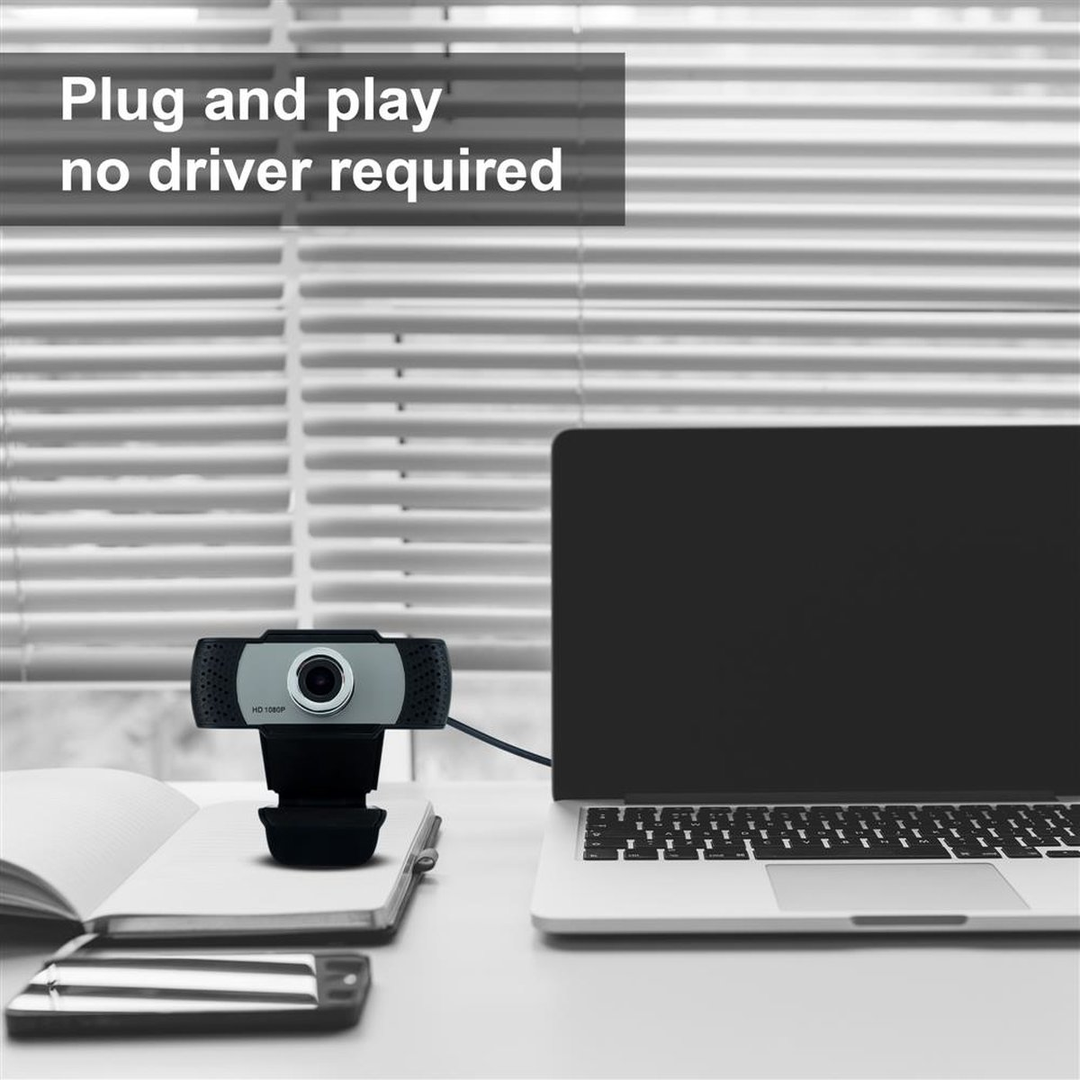 Eine Webcam auf einem Schreibtisch neben einem Laptop und einem Notizbuch. Der Text lautet "Plug and play no driver required".