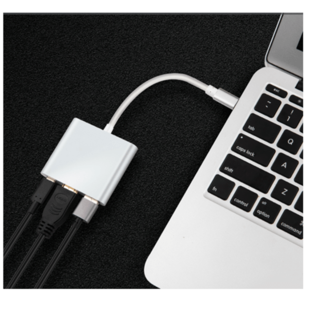Hub USB-C argentato collegato al laptop. Cavi neri si estendono dall'hub.