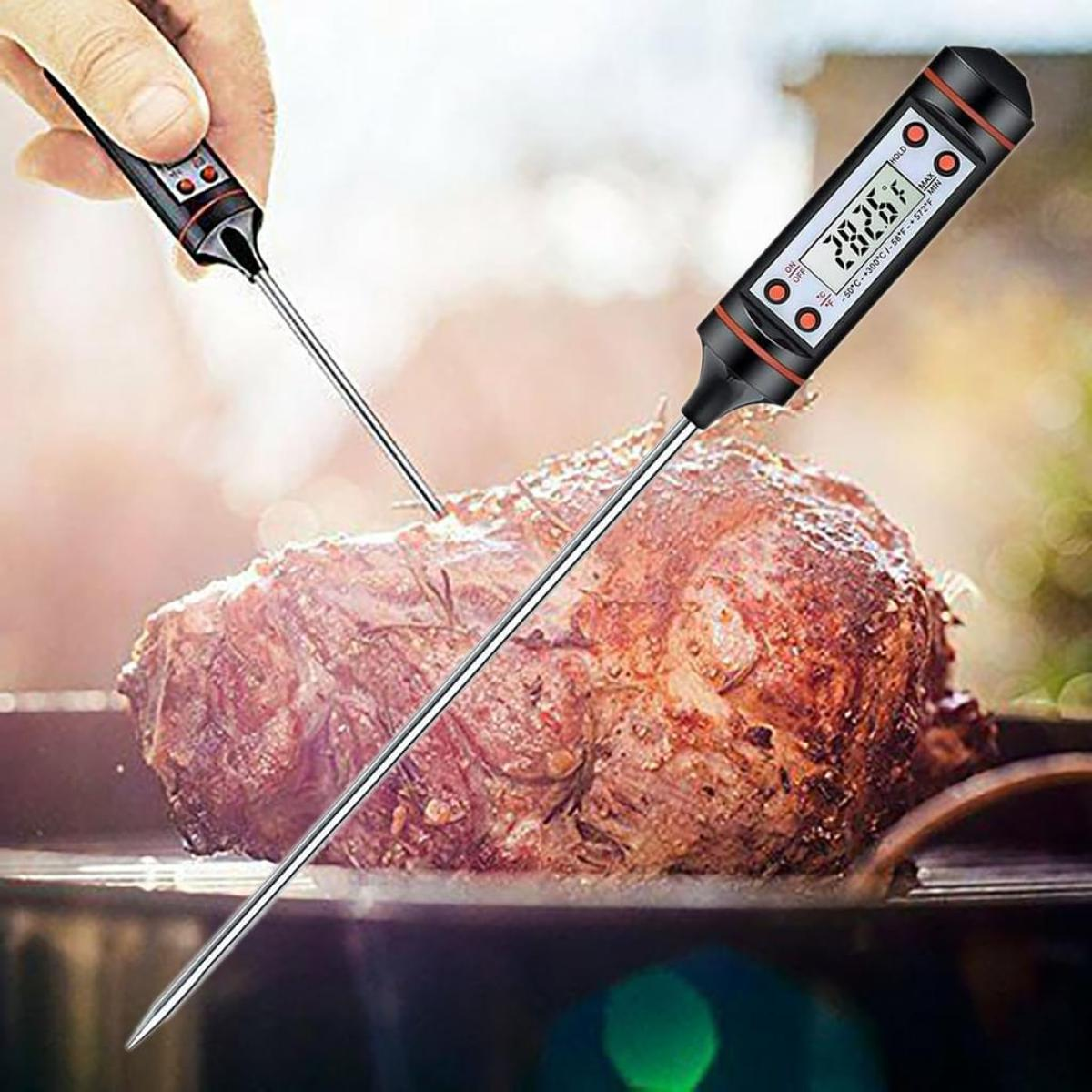 Zwei digitale Fleischthermometer, eines in einen gebratenen Braten gesteckt, unscharfer Hintergrund.