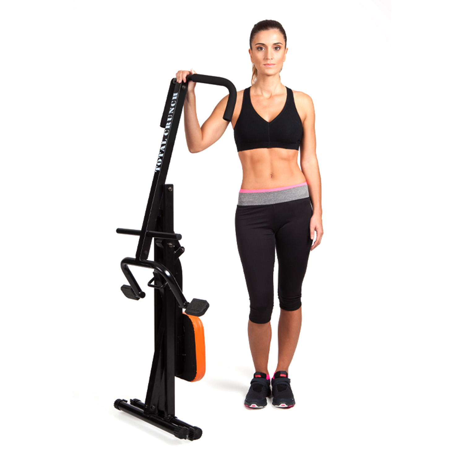 Donna in abbigliamento sportivo accanto a una macchina per esercizi Total Crunch, sfondo bianco.