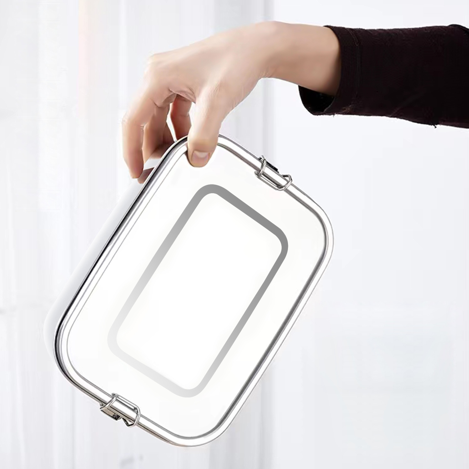 Eine Person hält eine Edelstahl-Lunchbox. Weißer Hintergrund.