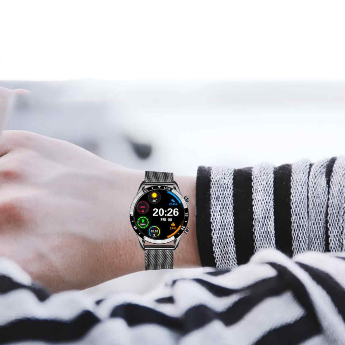 Silberne Smartwatch mit Uhrzeit, Datum und Statistiken. Getragen am Handgelenk mit einem Mesh-Armband.