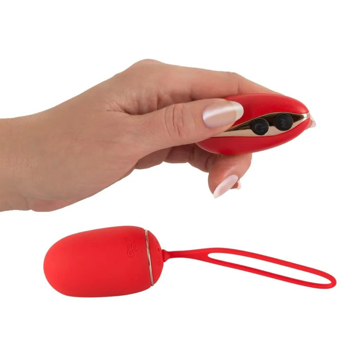 Eine Hand hält ein rotes Sexspielzeug. Darunter ein rotes, eiförmiges Spielzeug mit Schlaufe.