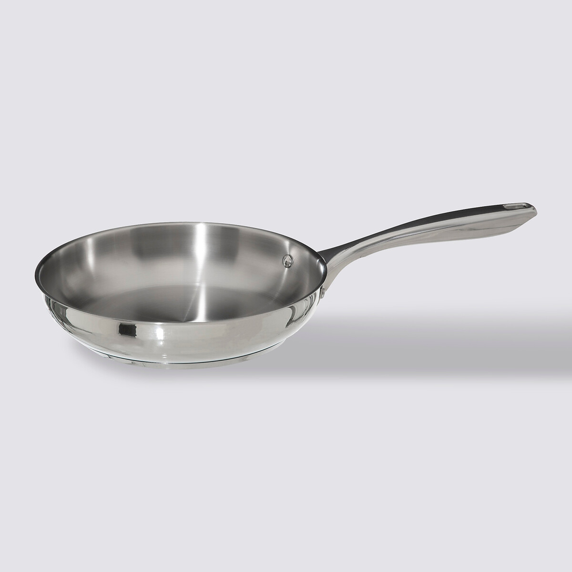 Sartén de acero inoxidable con mango largo sobre fondo gris claro. La sartén proyecta una sombra.