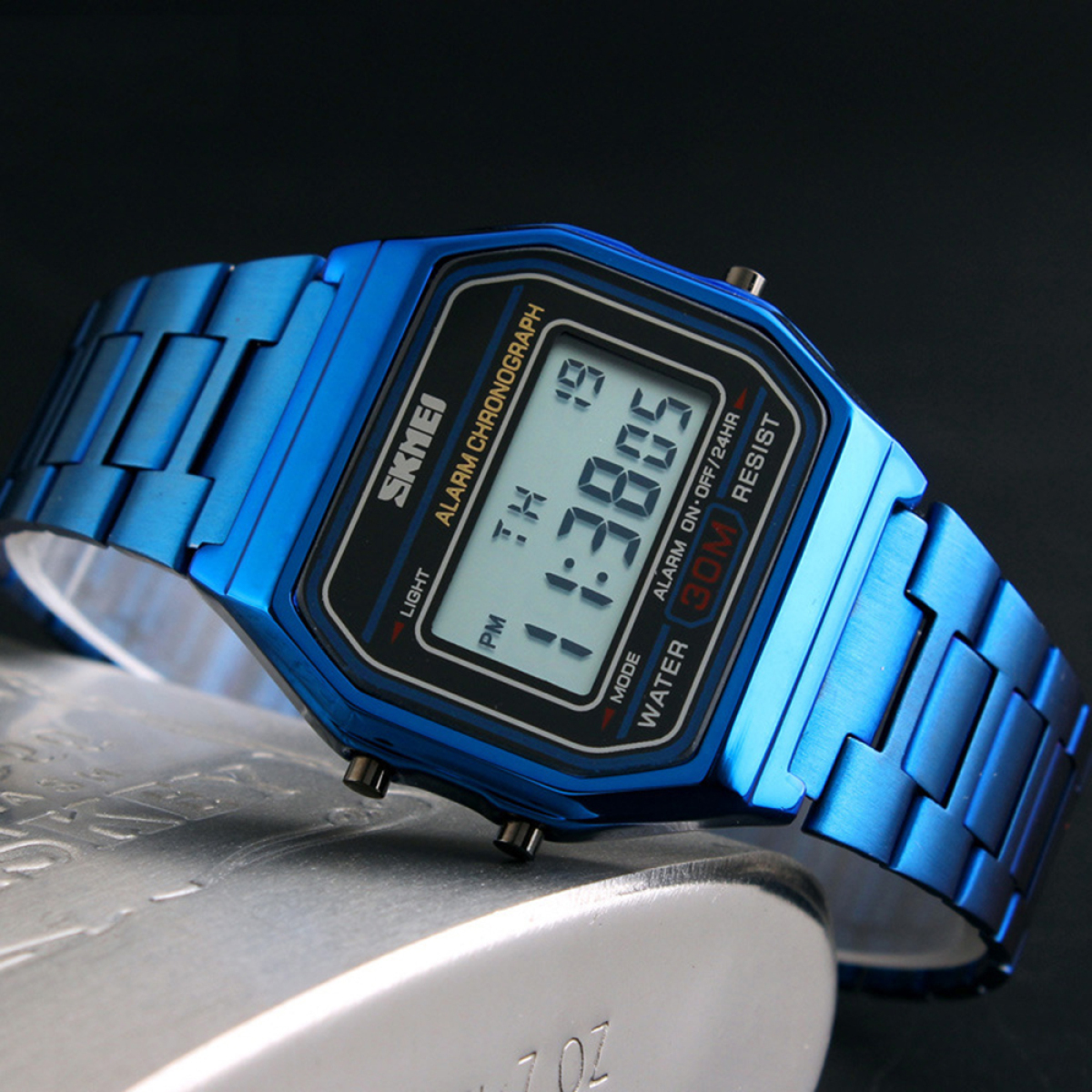 Eine blaue Digitaluhr mit Metallarmband, die Uhrzeit und andere numerische Daten anzeigt.