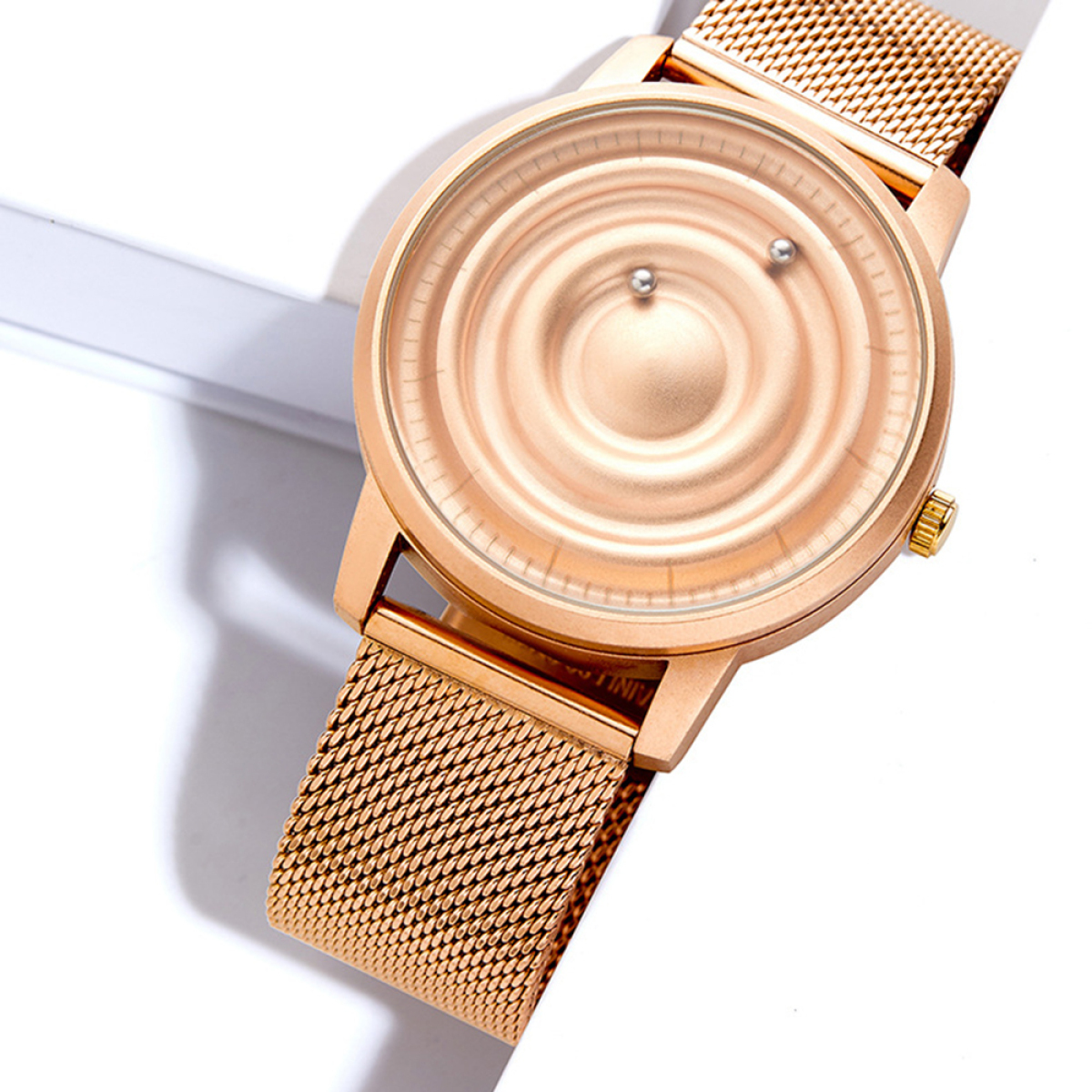 Goldene Uhr mit einzigartigem Zifferblatt und Mesh-Armband, auf weißem Untergrund.