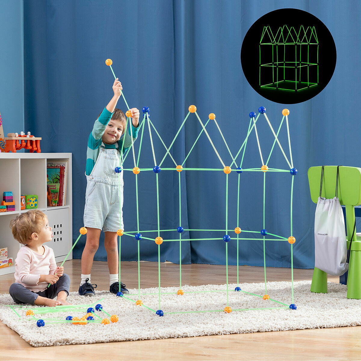 Due bambini costruiscono una struttura con bastoncini e sfere di plastica che si illuminano al buio.