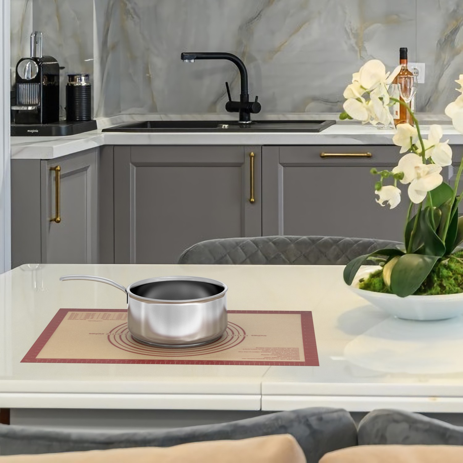 Kücheninterieur mit Tisch, Topf, Blumen und anderen Gegenständen. Graue Schränke, Marmorhintergrund.