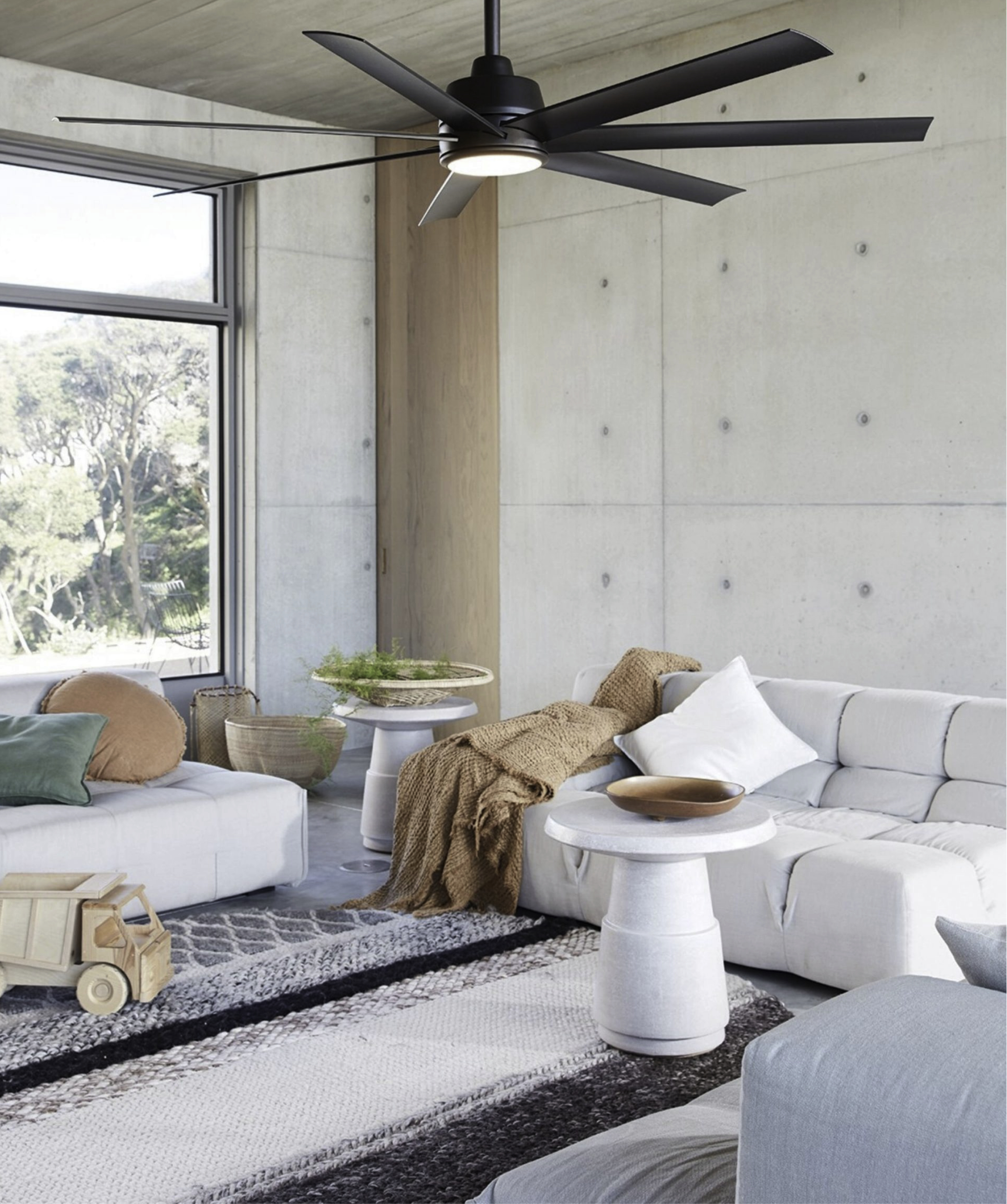 Modernes Wohnzimmer mit schwarzem Deckenventilator, weißem Sofa, Holzakzenten und großem Fenster.