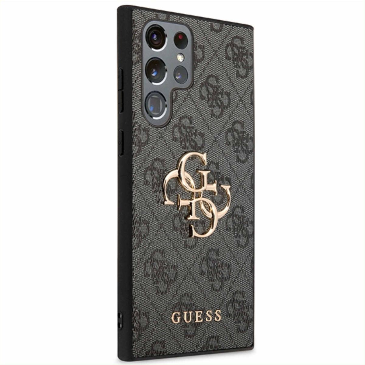 Una custodia per telefono con un logo Guess, in un motivo, su un telefono. La custodia è su un tavolo.