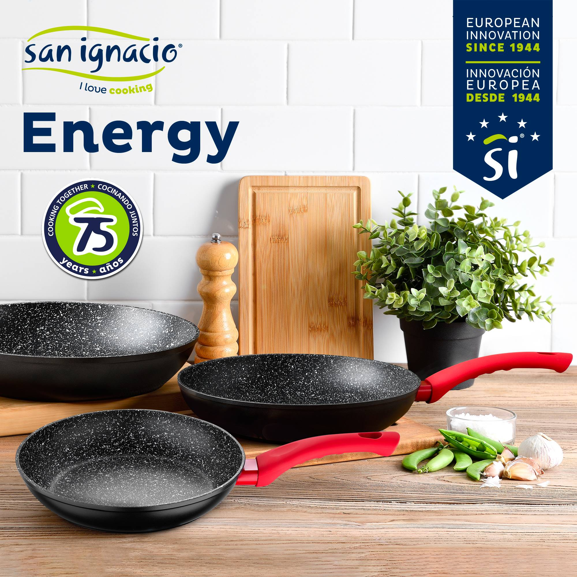 Sartenes y utensilios de cocina sobre una mesa de madera. Hay una tabla de cortar, sal y una planta.