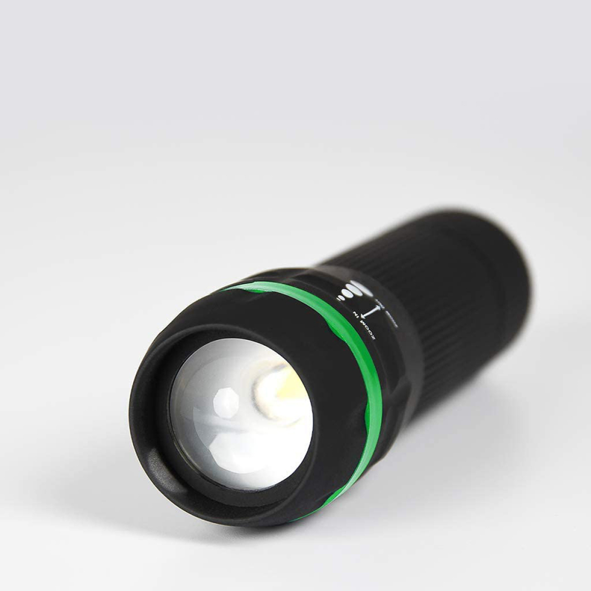 Schwarze Taschenlampe mit grünem Ring und hellem Licht.