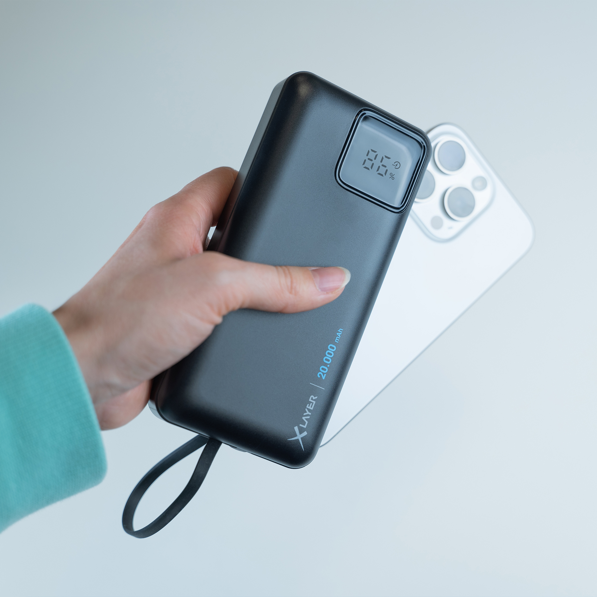 Eine schwarze Powerbank wird in einer Hand gehalten. Die Powerbank zeigt den Akkustand an.