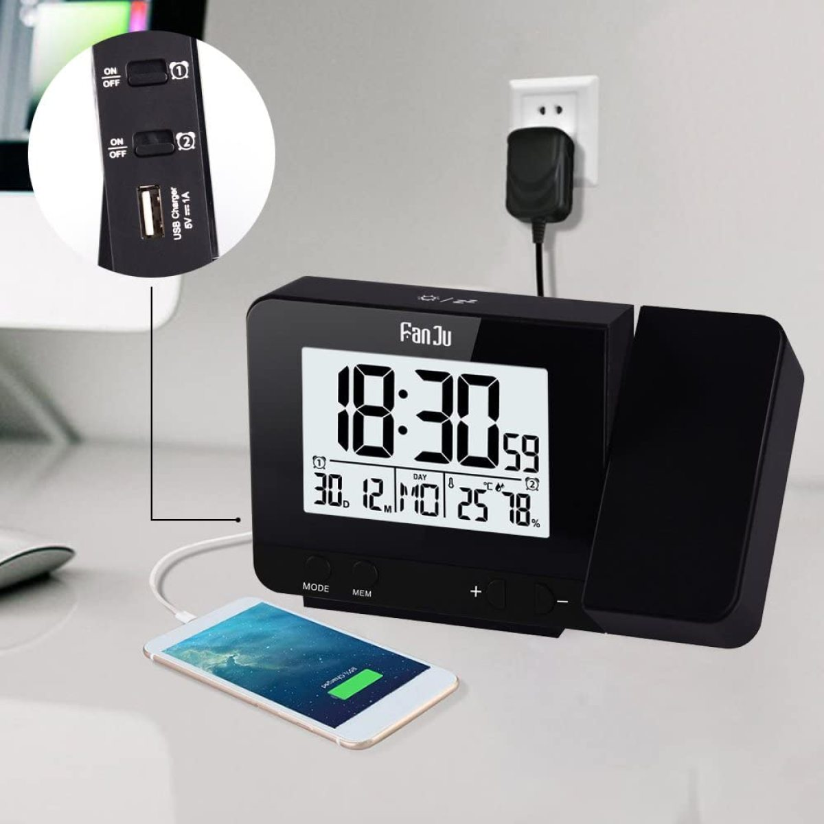 Eine schwarze Digitaluhr mit einem Telefon, das auf einem Schreibtisch geladen wird, zeigt Zeit und Wetter.