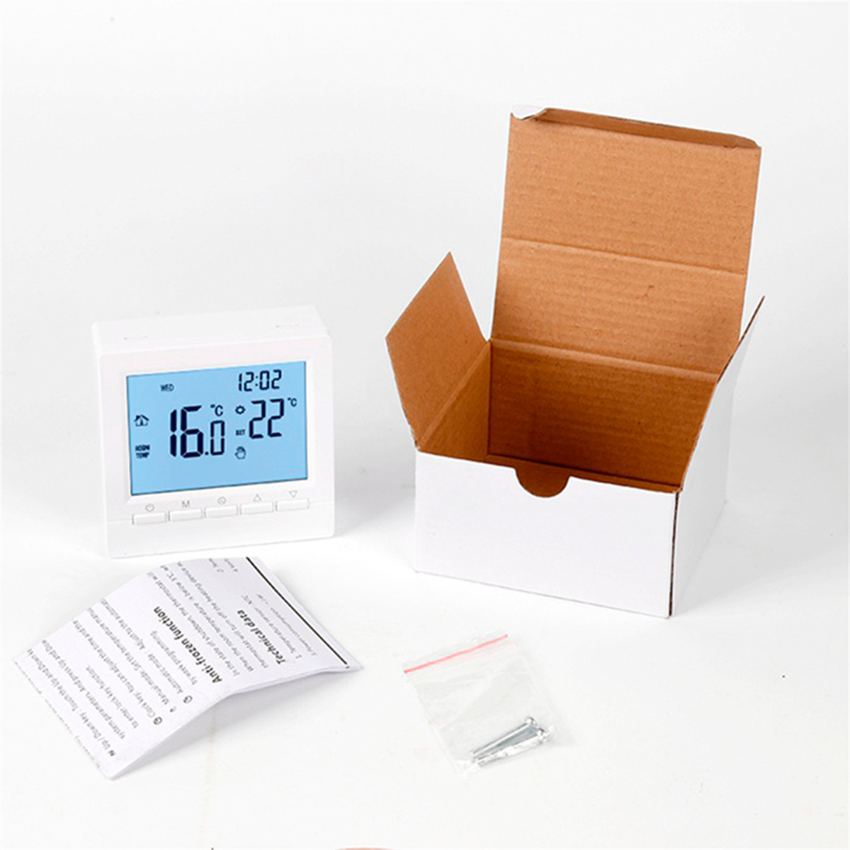 Weißes Thermostat mit Digitalanzeige, Box und Anweisungen. Temperatur wird angezeigt.