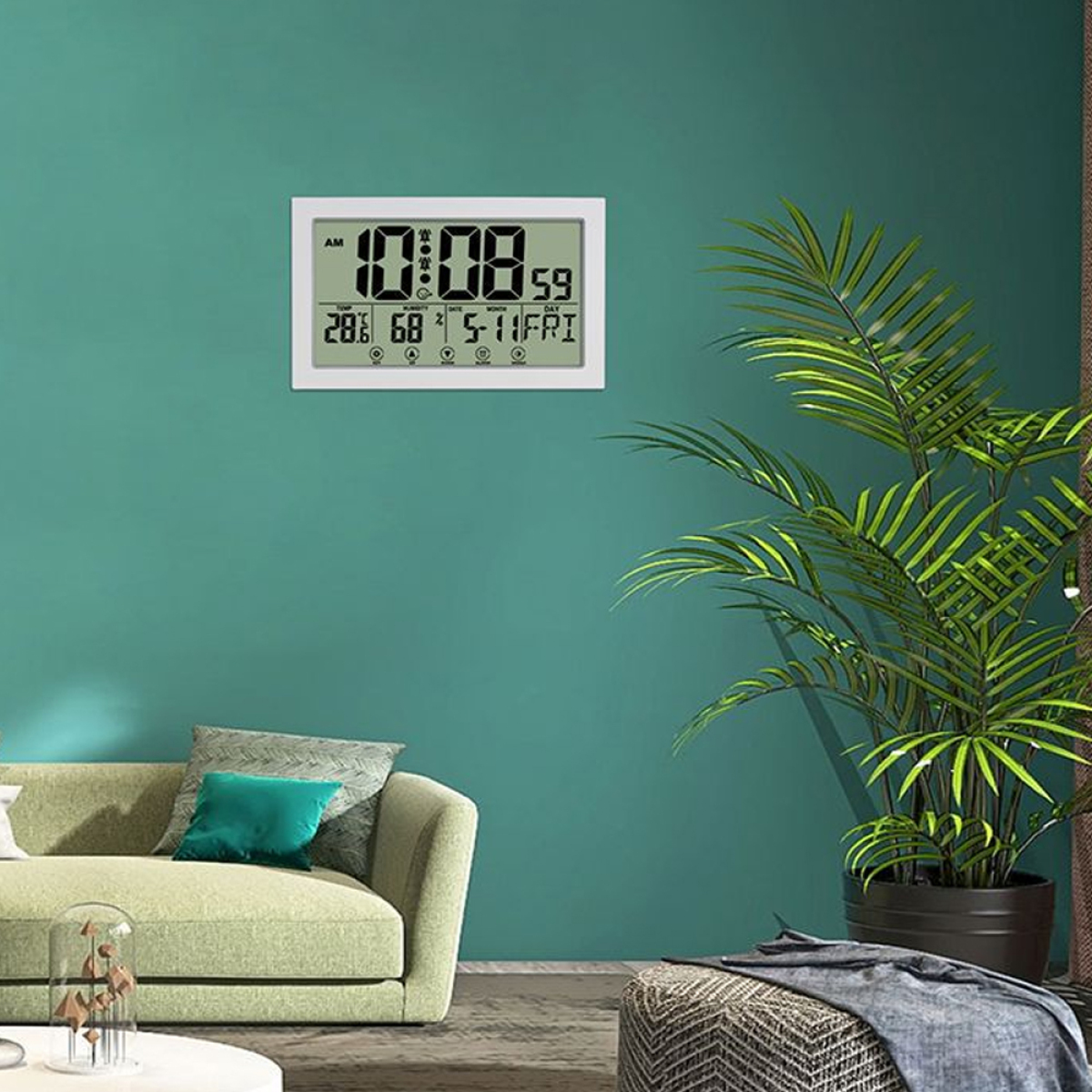 Digitaluhr mit Uhrzeit und Datum an einer türkisfarbenen Wand, mit einer grünen Pflanze und einem Sofa.
