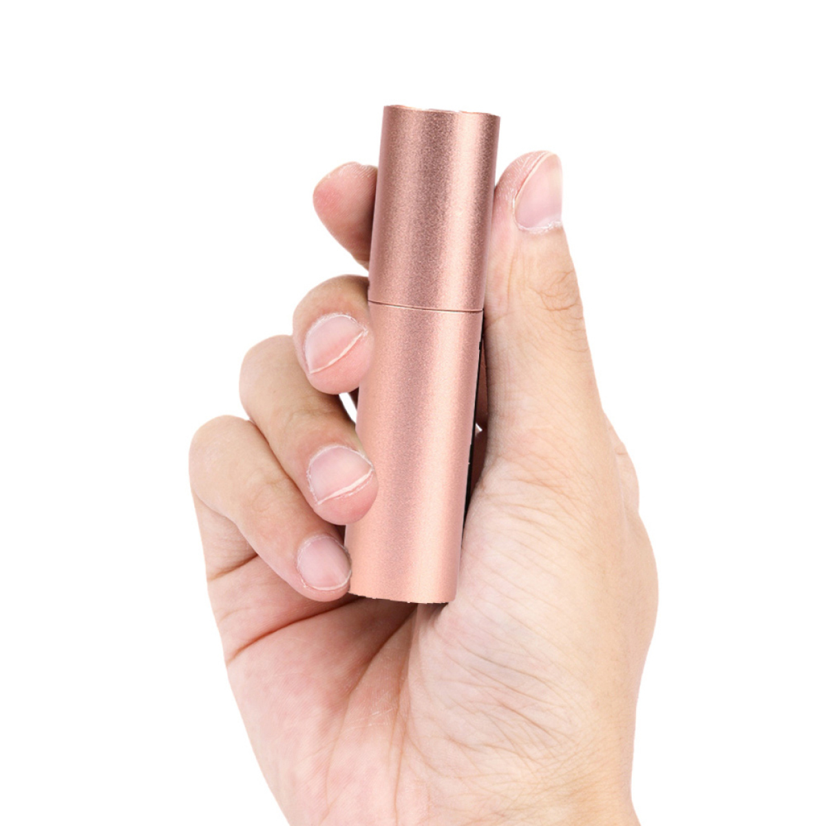 Hand hält roségoldenen Lippenstiftbehälter, weißer Hintergrund.