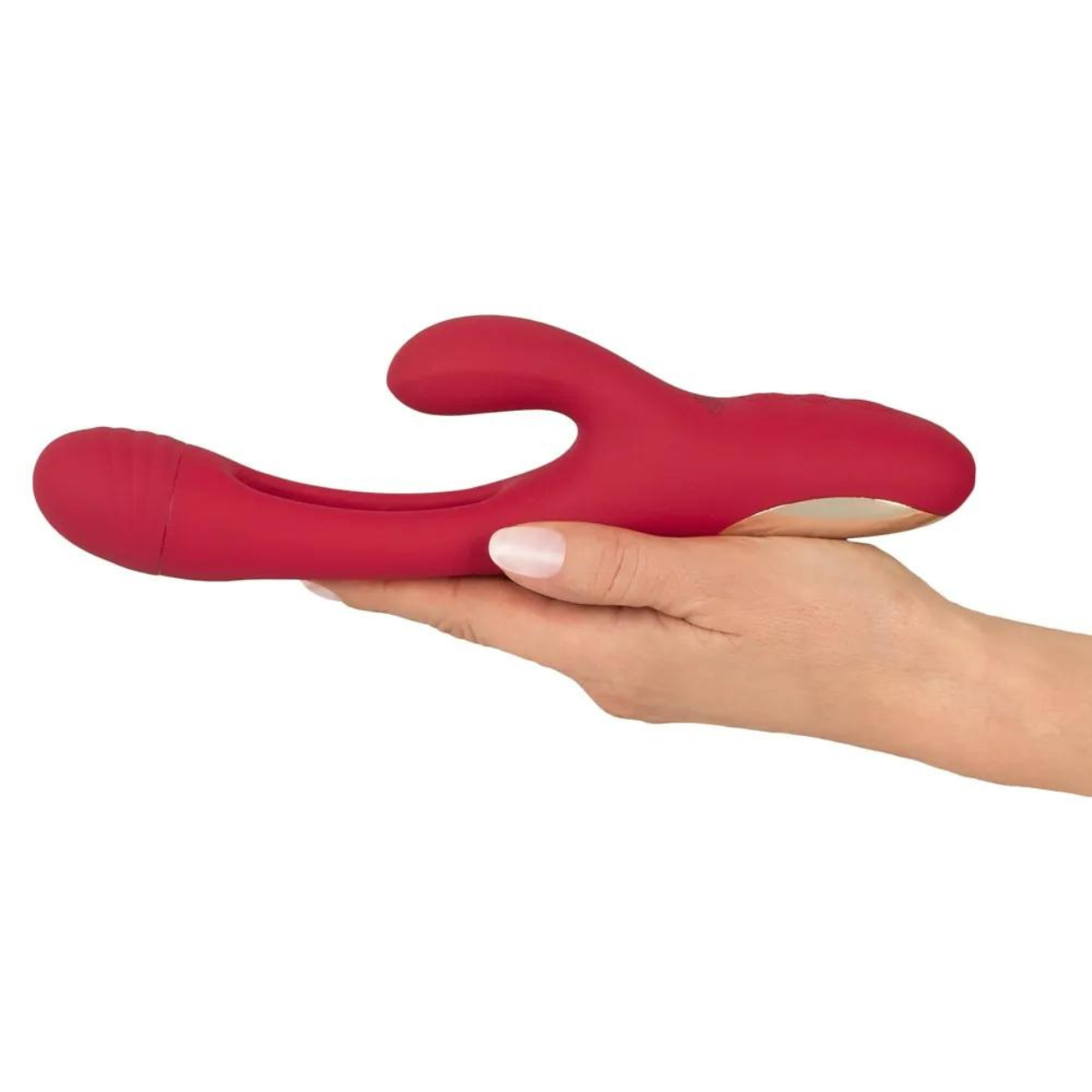 Ein rotes Sexspielzeug in einer Hand gehalten. Es hat eine geschwungene Form und einen goldenen Sockel.