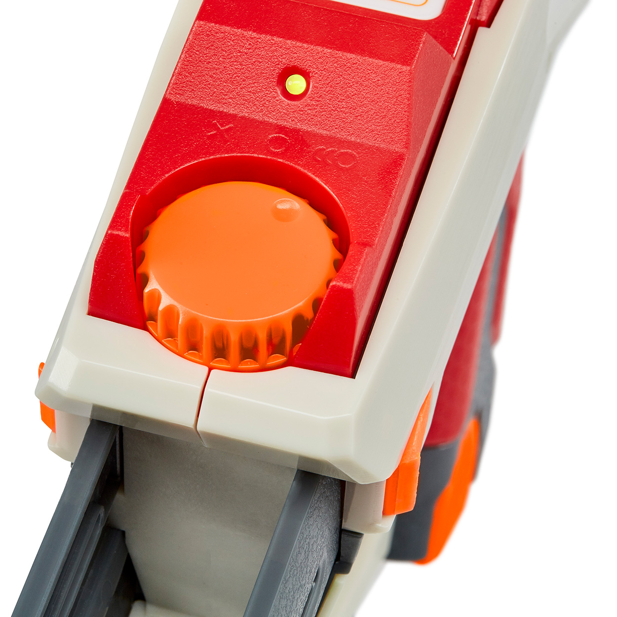 Nahaufnahme einer rot-weißen Spielzeugpistole mit orangefarbenem Drehknopf und roter Taste.