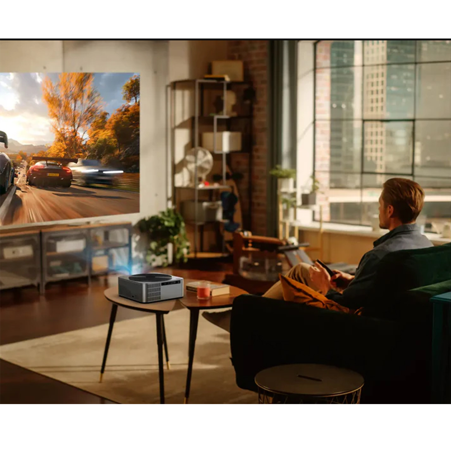 Mężczyzna oglądający wyświetlany wyścig na stole, z projektorem i salonem.