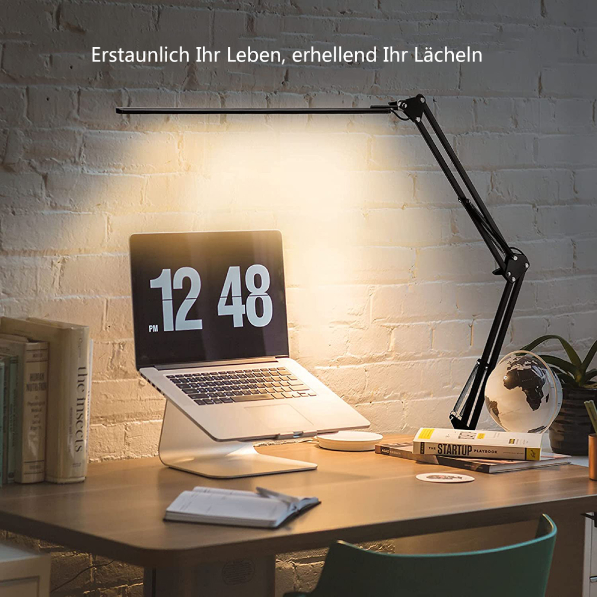 Schreibtisch mit Laptop, Schreibtischlampe, Büchern und einem Globus. Die Lampe beleuchtet die Szene.