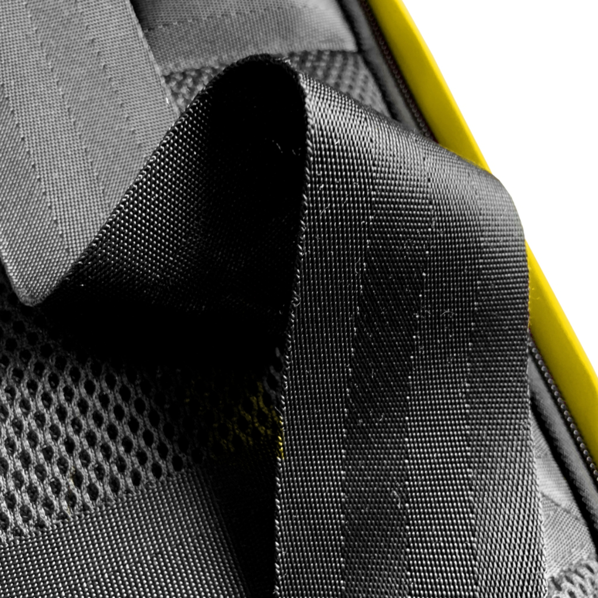Primer plano de un cinturón de seguridad negro con patrón texturizado. Detalle de borde amarillo.