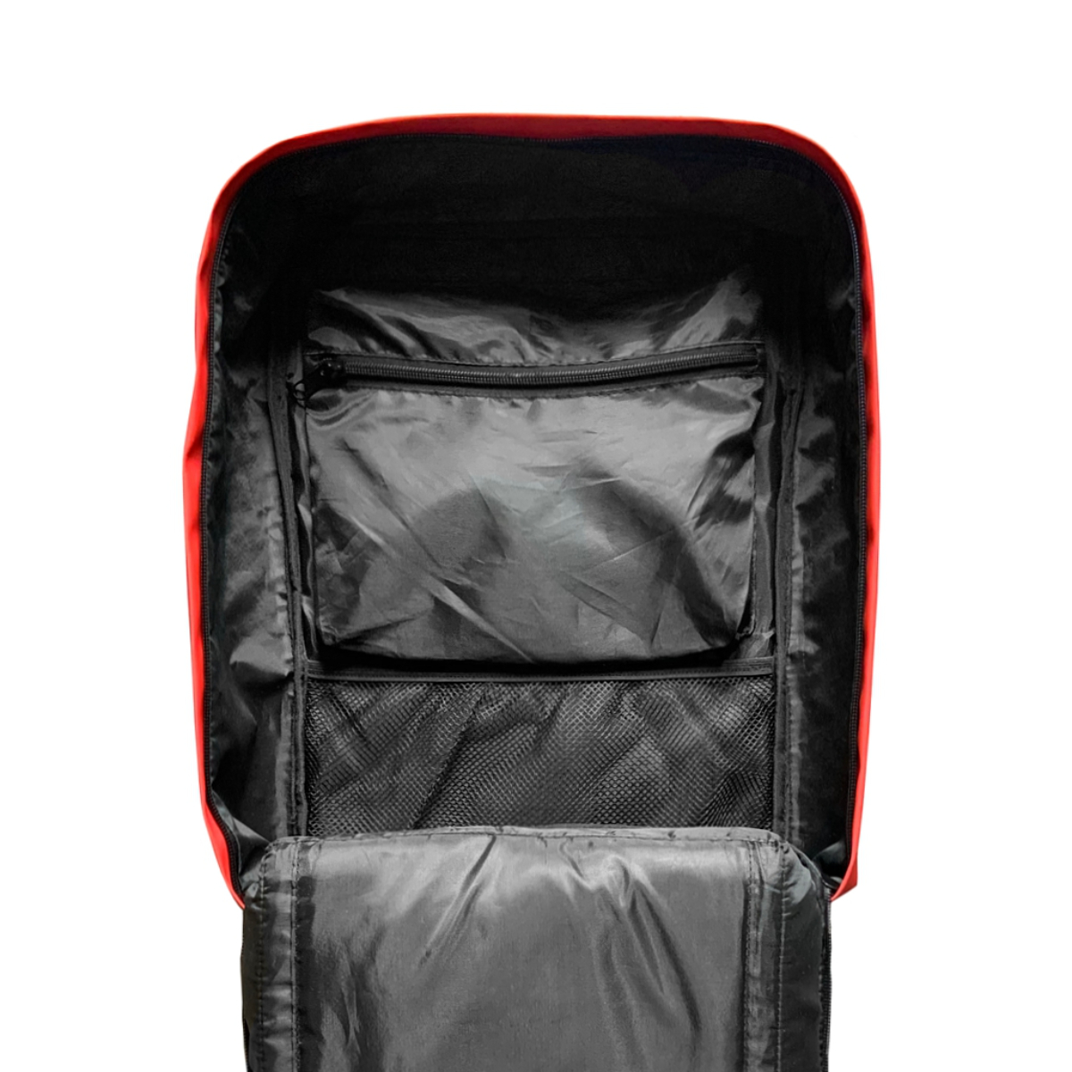Interior de mochila roja abierta, mostrando forro negro, bolsillo con cremallera y bolsillos de malla.